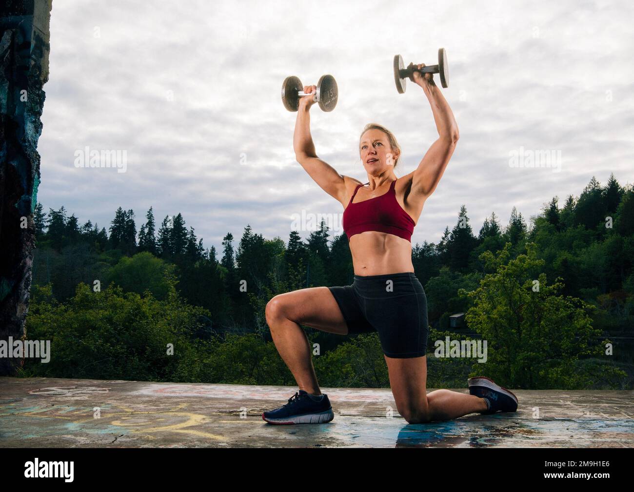 Donna che si esercita all'aperto con manubri, Bainbridge Island, Washington, USA Foto Stock