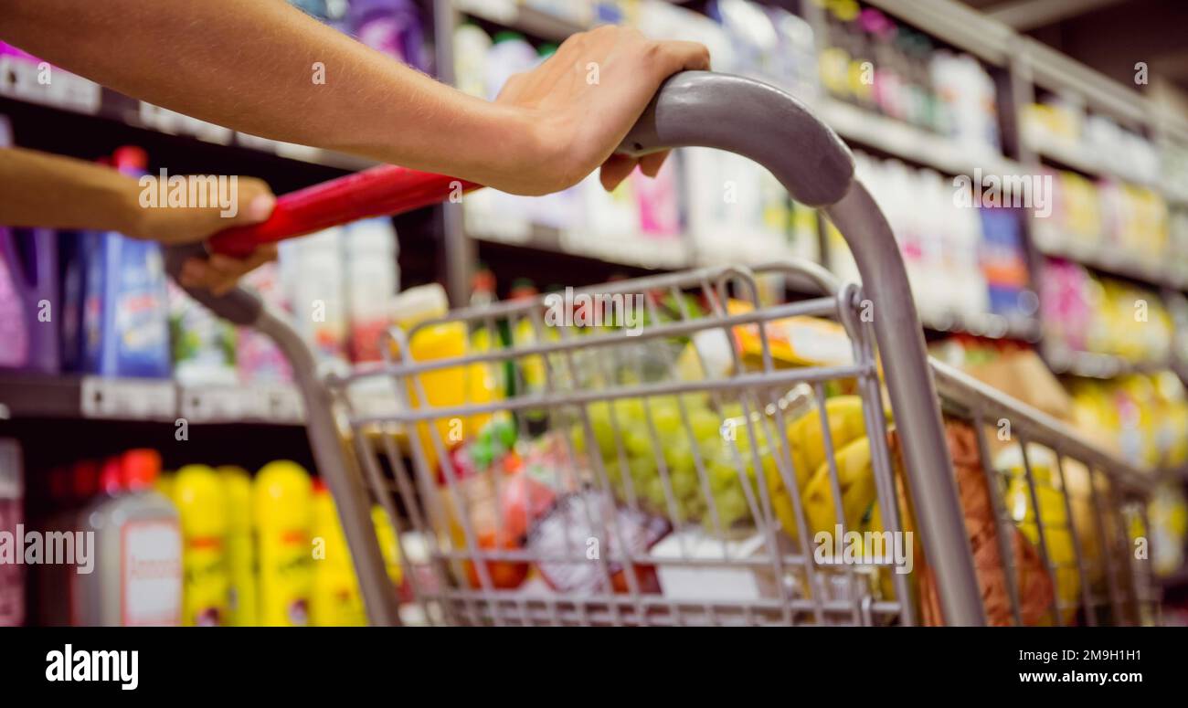 Mani di donna caucasica che tiene carrello di shopping nel mercato alimentare Foto Stock