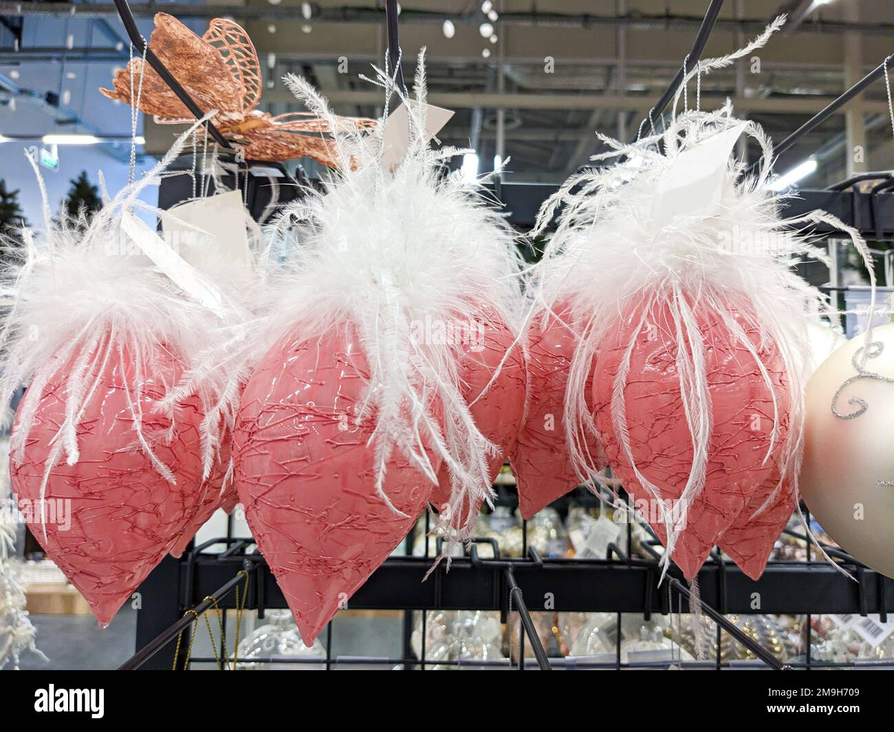 Originali giocattoli di Natale interessanti - palline a forma di cono rosa con piume bianche Foto Stock