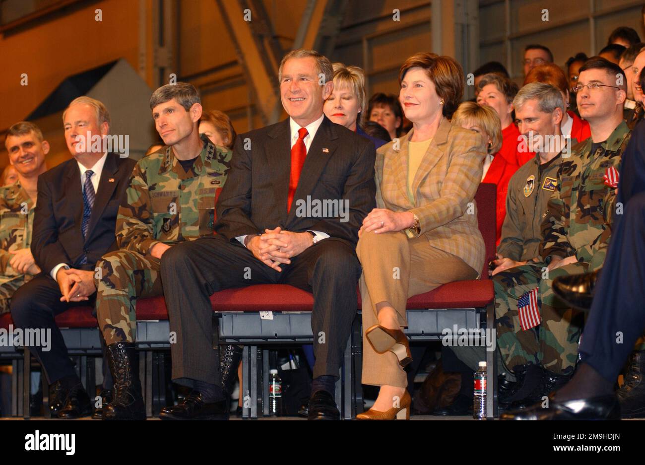 020216-F-9311L-006. [Complete] Scene Caption: IL presidente DEGLI STATI UNITI e la signora George W. Bush siedono insieme sul palco prima di una casa piena in Hangar 3 alla base dell'aeronautica militare di Elmendorf, Alaska. Durante il suo viaggio in Giappone, si fermò alla Elmendorf AFB, Alaska, dove parlò con una casa piena entusiasta nella gruccia. Il Presidente ha espresso il suo orgoglio per le forze statunitensi; "è onorato di trovarsi in un luogo in cui le persone capiscono la necessità di sacrifici e patriottismo", ha affermato il Presidente. Ha anche parlato del ruolo di Elmendorf AFB e Alaska nell'operazione NOBLE EAGLE e della guerra contro il terrorismo. Ai presidenti di sinistra ci siedono Foto Stock