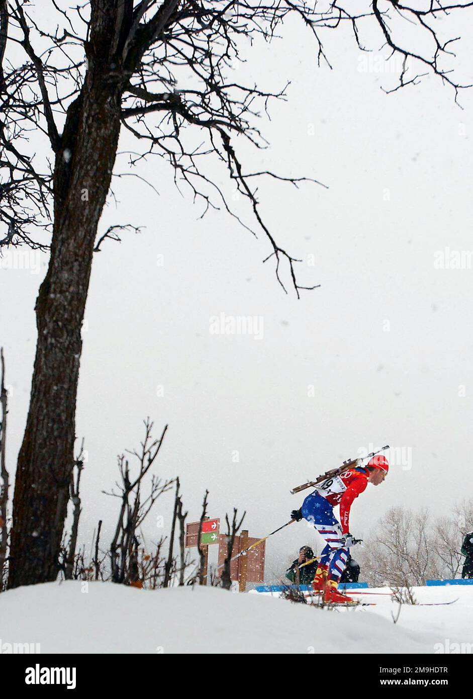 Con il suo fucile bolt-action del calibro di .22 sbattuto sulla schiena, JEREMY Teela, specialista mondiale dell'atleta, USA, si fa strada sul campo, sugli sci, durante la prima tappa del concorso da uomo Biathlon Relay 4 x 7,5km al Soldier Hollow di Midway, Utah, durante i GIOCHI OLIMPICI INVERNALI del 2002. Il concorso Relay è composto da quattro membri della squadra; ciascuno deve sciare 7,5 km, con due colpi di fuoco, uno prono e uno in piedi, ciascuno con fucile non supportato. Gli Stati Uniti finirebbero la gara al 15th° posto, 6:44,8 alle spalle del leader. Soggetto operativo/Serie: 2002 GIOCHI OLIMPICI INVERNALI base: Midway Foto Stock