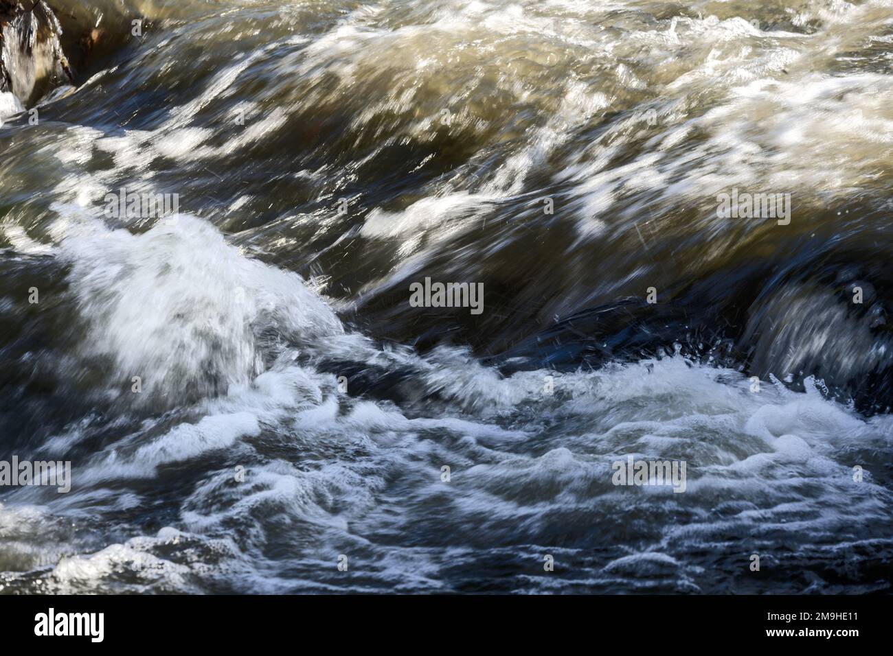 Acqua che scorre in una piccola cascata Foto Stock