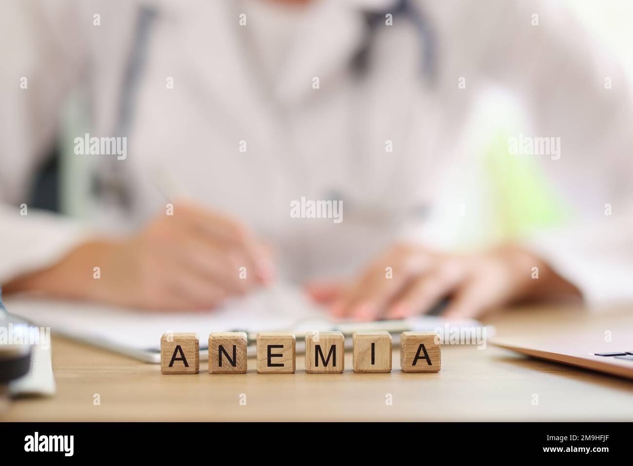Iscrizione ANEMIA su cubi di legno e medico di controllo esami medici in background. Foto Stock