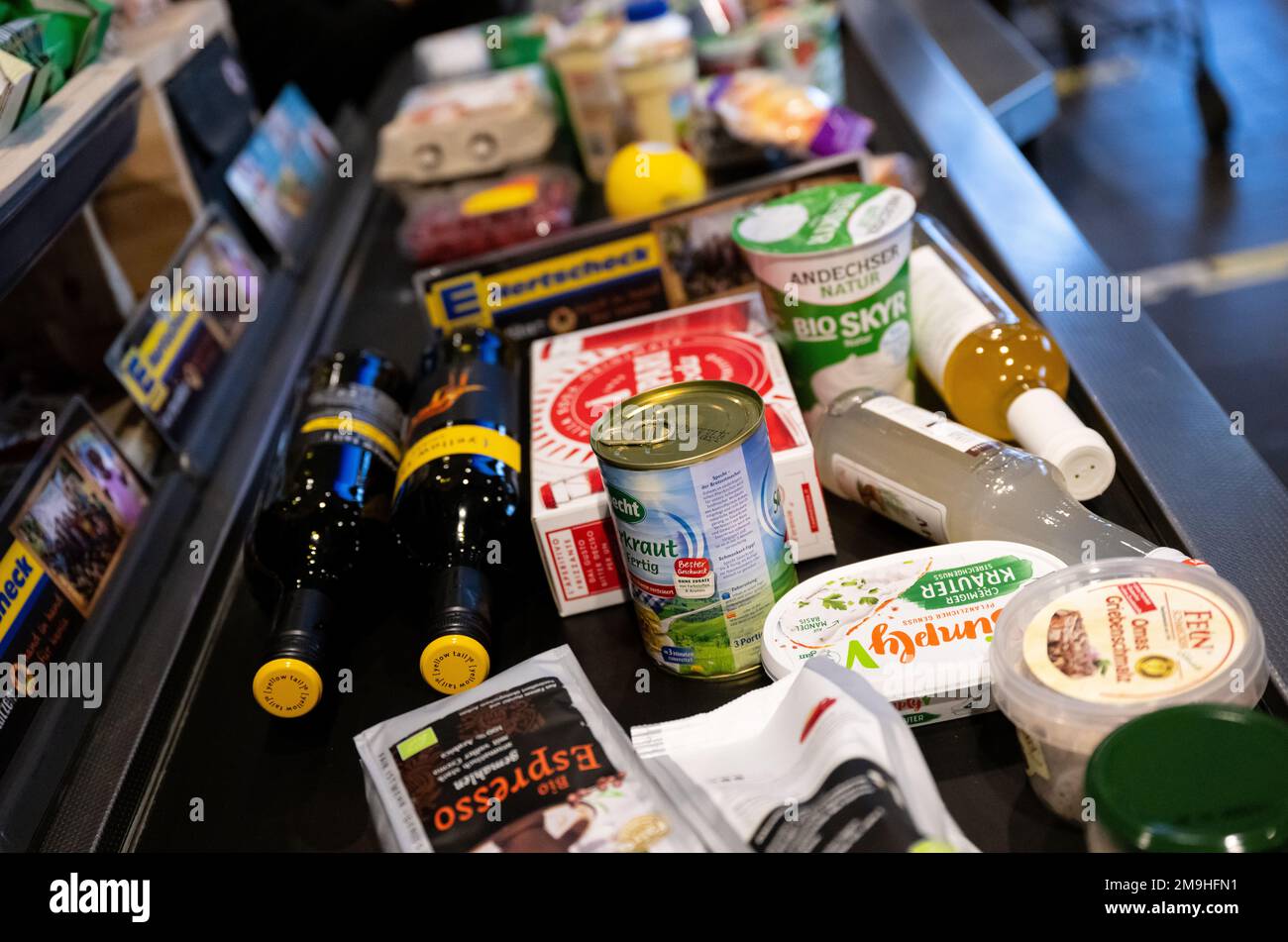 Neubiberg, Germania. 18th Jan, 2023. Gli alimenti si trovano sul nastro trasportatore al momento del check-out in un supermercato. Sotto l'impatto di un'elevata inflazione, le associazioni dei consumatori si aspettano che i prezzi dei prodotti alimentari continuino a crescere. Credit: Sven Hoppe/dpa/Alamy Live News Foto Stock