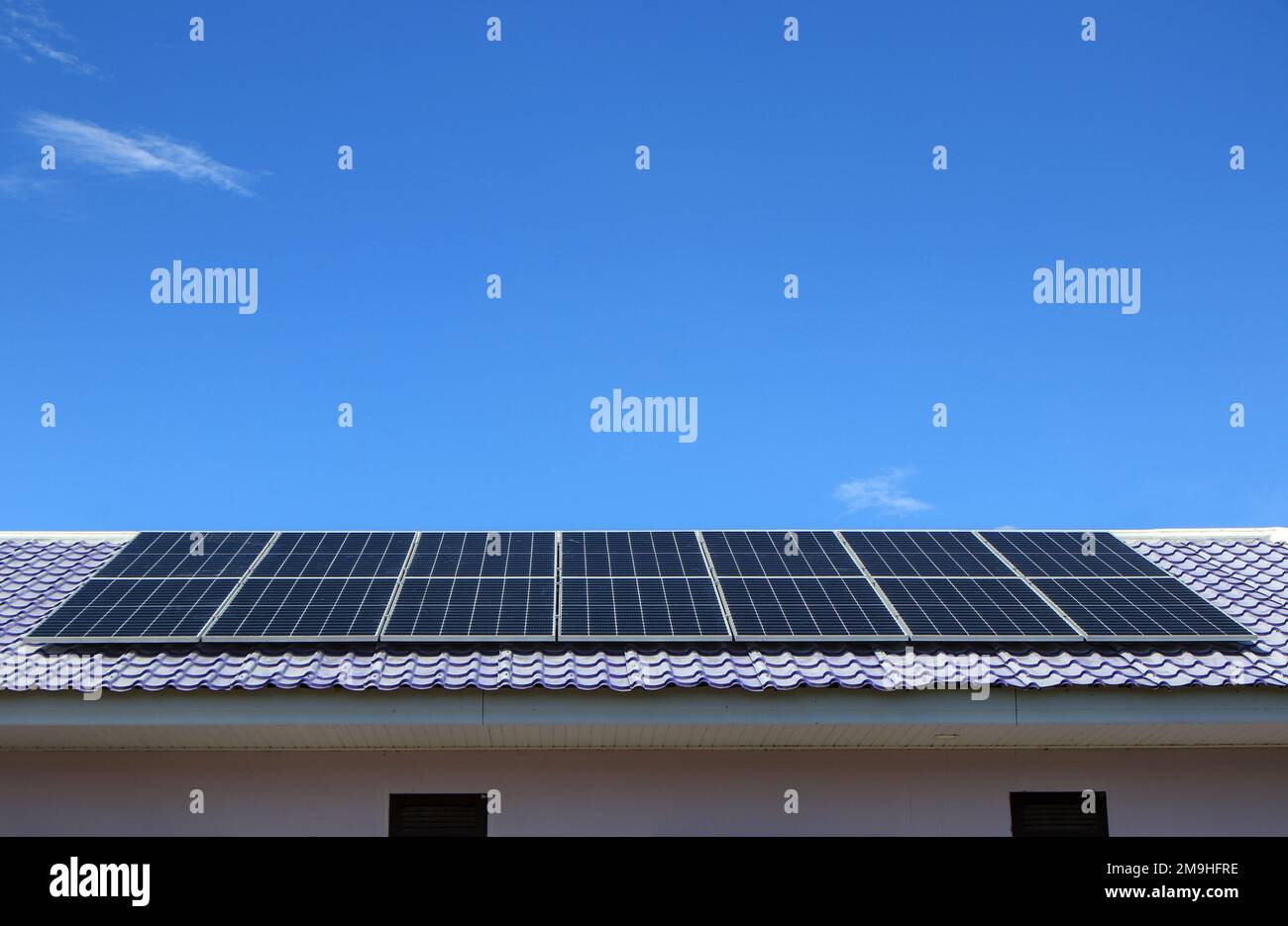 Installare nuovi pannelli solari sul tetto in lamiera di metallo della casa  dove l'elettricità è ancora inaccessibile Foto stock - Alamy