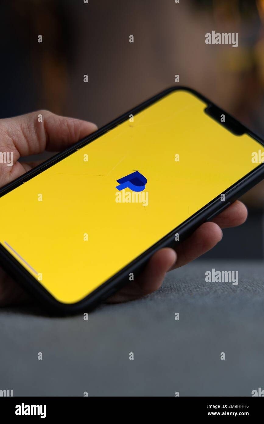 Tenere in mano uno smartphone con l'icona PayPal sullo schermo. Logo pal  pay blu su schermo giallo. IPhone con app finanziaria e bancaria.  Amsterdam, Paesi Bassi 202 Foto stock - Alamy