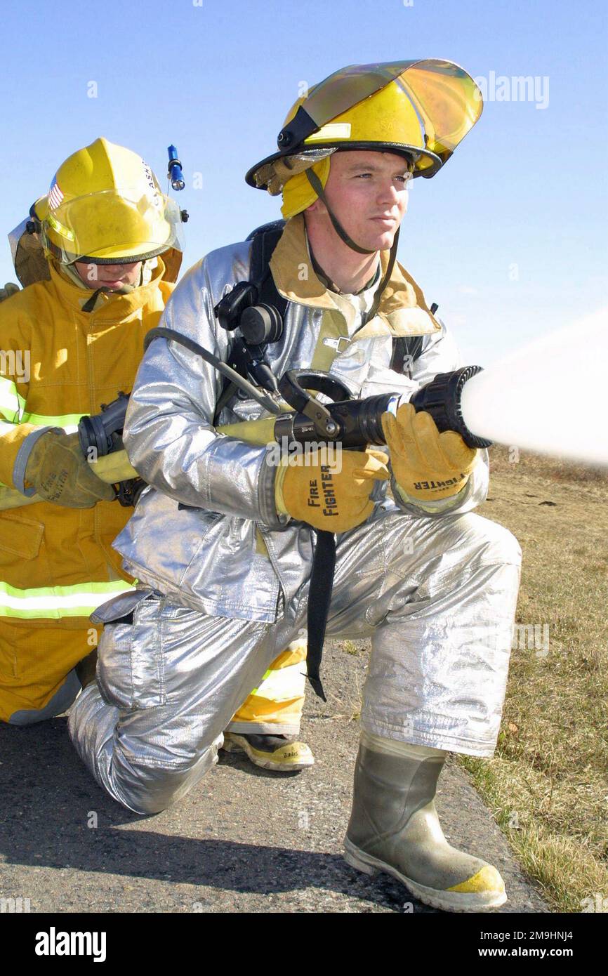 Vigili del fuoco, in tuta di prossimità completa, 148th Fighter Wing (FW), 148th Civil Engineer Squadron (CES), Minnesota Air National Guard (MNANG), lasciare sciogliere torrenti di acqua con una manichetta antincendio durante un esercizio di allenamento. Gli aeratori, attivati a supporto dell'operazione NOBLE EAGLE, stanno conducendo esercizi di addestramento come parte di uno scenario di esercizio di ventilazione/Risposta strutturale. Oggetto/Serie: NOBLE EAGLE base: Duluth International Airport Stato: Minnesota (MN) Paese: Stati Uniti d'America (USA) Foto Stock