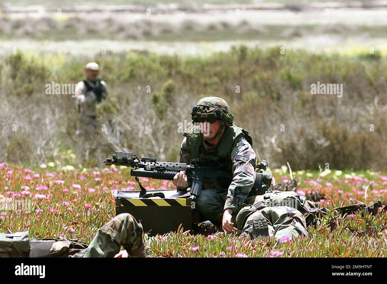 020507-F-3717R-015. [Complete] Scene Caption: US Air Force (USAF) SENIOR AIRMAN (SRA) AIRMAN Joshua Hinsey, una polizia di sicurezza (SP) assegnata alla 460th Air base Wing (ABW), Security Forces Squadron (SFS), Buckley Air Force base (AFB), Colorado (CO), Porta con sé il fucile M16A1 5,56mm con un lanciagranate 40mm M203 dotato di Multiple Integrated laser Engagement System (MILES) mentre recupera una mappa della missione dal suo compagno di squadra, durante la competizione tattica delle forze di sicurezza condotta presso la Vandenberg Air Force base (AFB) California (CA), durante Exercise GUARDIAN CHALLENGE 2002. Cha Guardiano Foto Stock