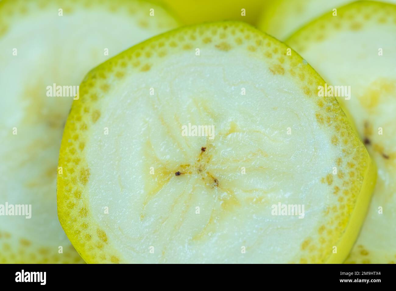 Fette di banana tagliate con la pelle in un macro shot molto vicino, sfondo. Foto Stock