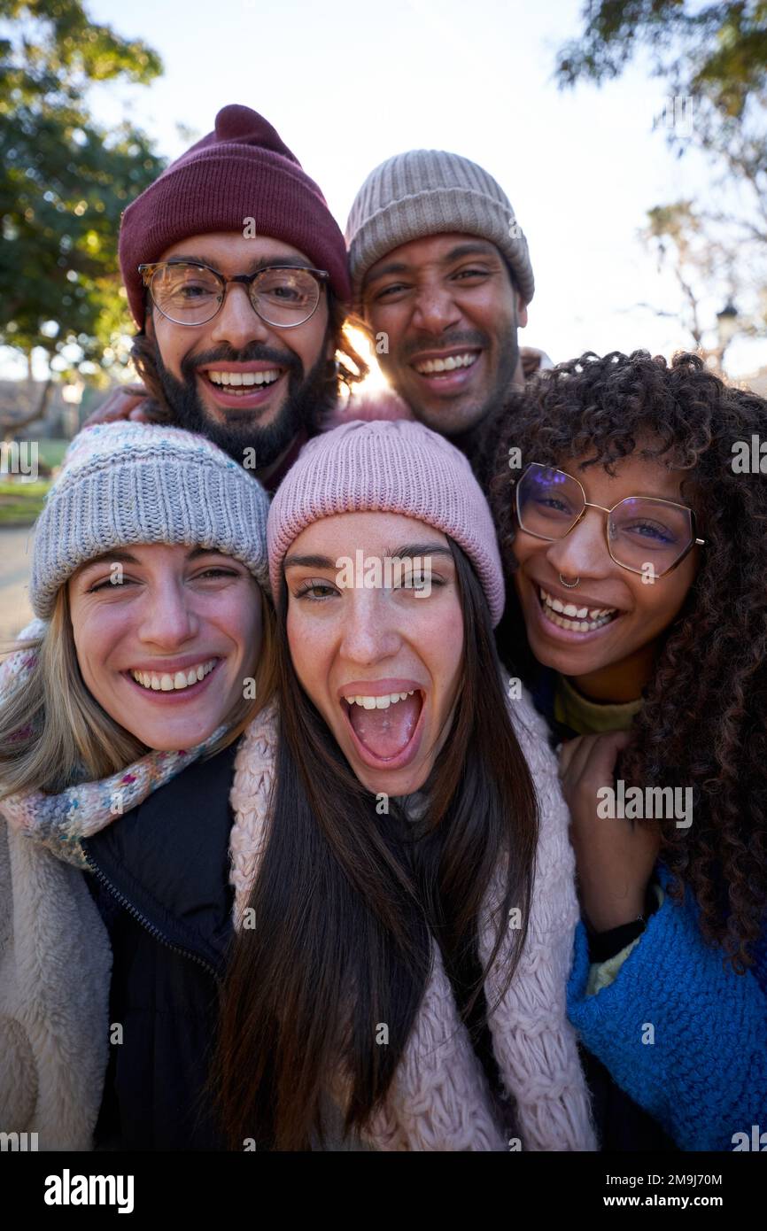 Gruppo multietnico di persone che prendono selfie all'aperto guardando la fotocamera allegramente. Foto Stock