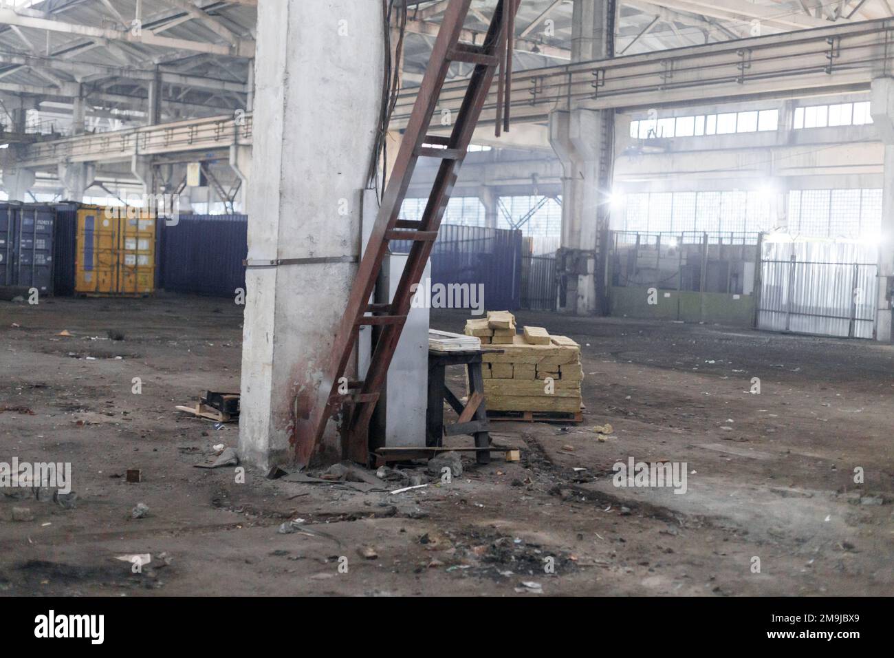 La luce del sole splende attraverso le finestre di un vecchio edificio di magazzino industriale abbandonato. Foto di alta qualità Foto Stock