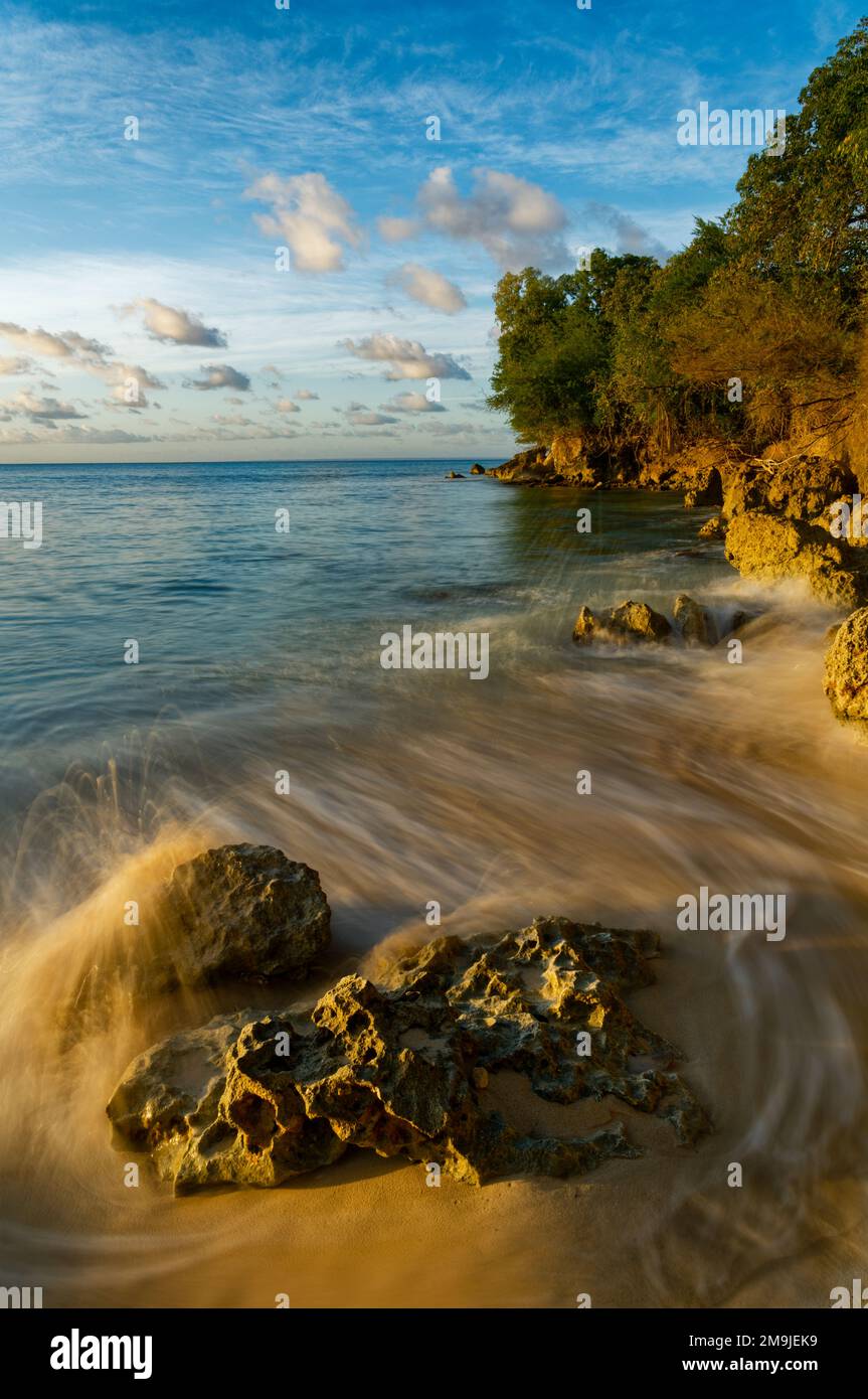 Tramonto sulle onde e formazione rocciosa, Grand Bourg Beach, Marie-Galante, Guadalupa, Francia Foto Stock