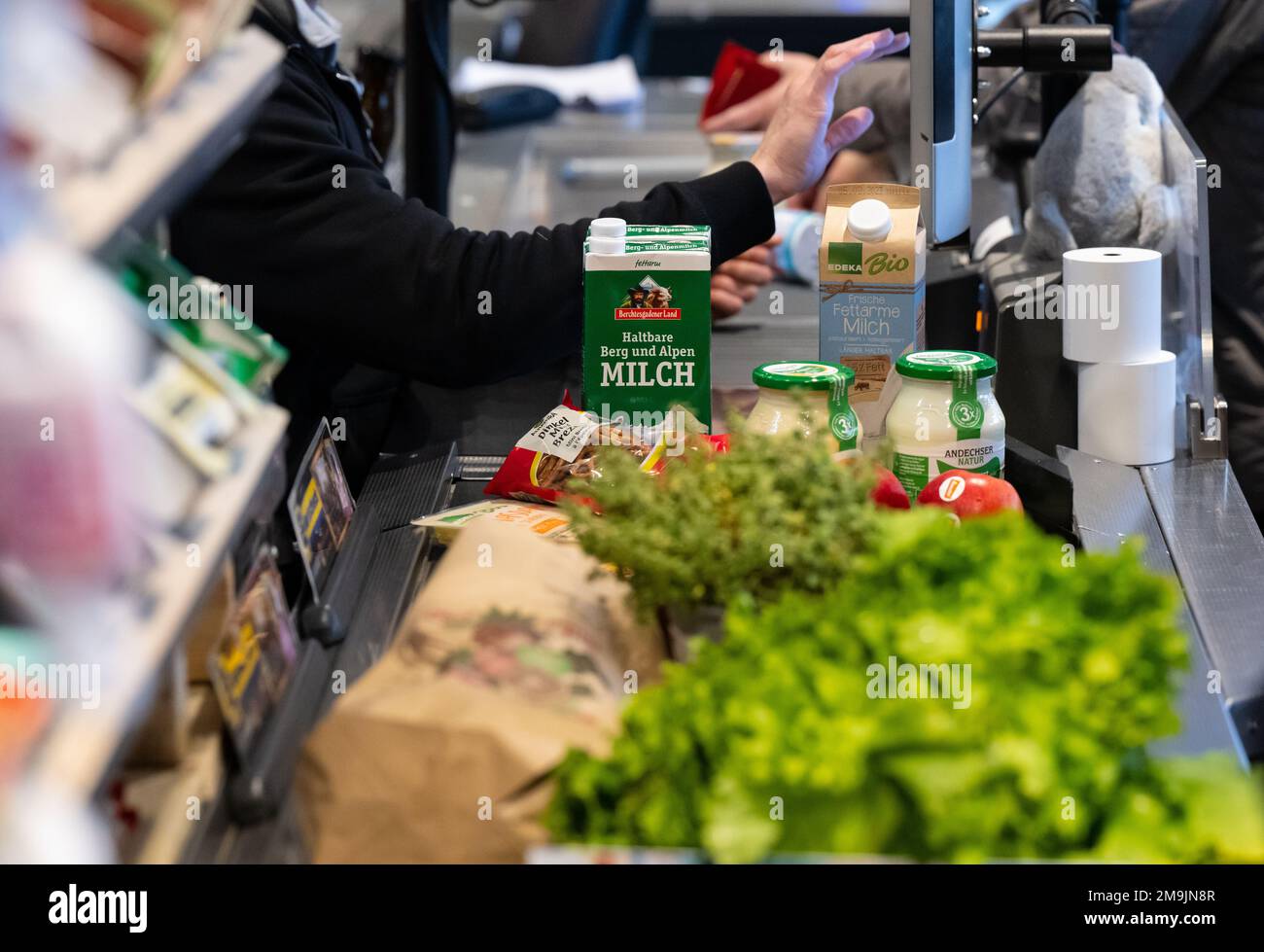 Neubiberg, Germania. 18th Jan, 2023. Gli alimenti si trovano sul nastro trasportatore al momento del check-out in un supermercato. Sotto l'impatto di un'elevata inflazione, le associazioni dei consumatori si aspettano che i prezzi dei prodotti alimentari continuino a crescere. Credit: Sven Hoppe/dpa/Alamy Live News Foto Stock