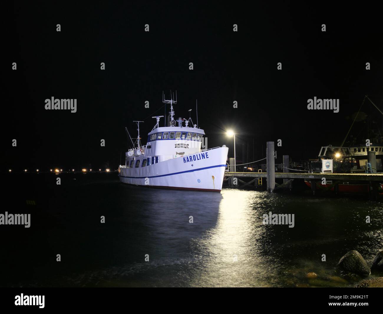 Vista obliqua di una nave bianca nel porto di Burg auf Fehmarn in Germania di notte Foto Stock