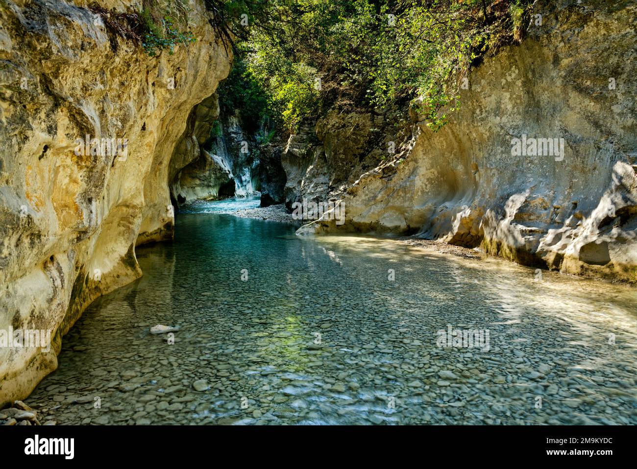 Ruscello che scorre attraverso rocce e una grotta, Provenza, Francia Foto Stock