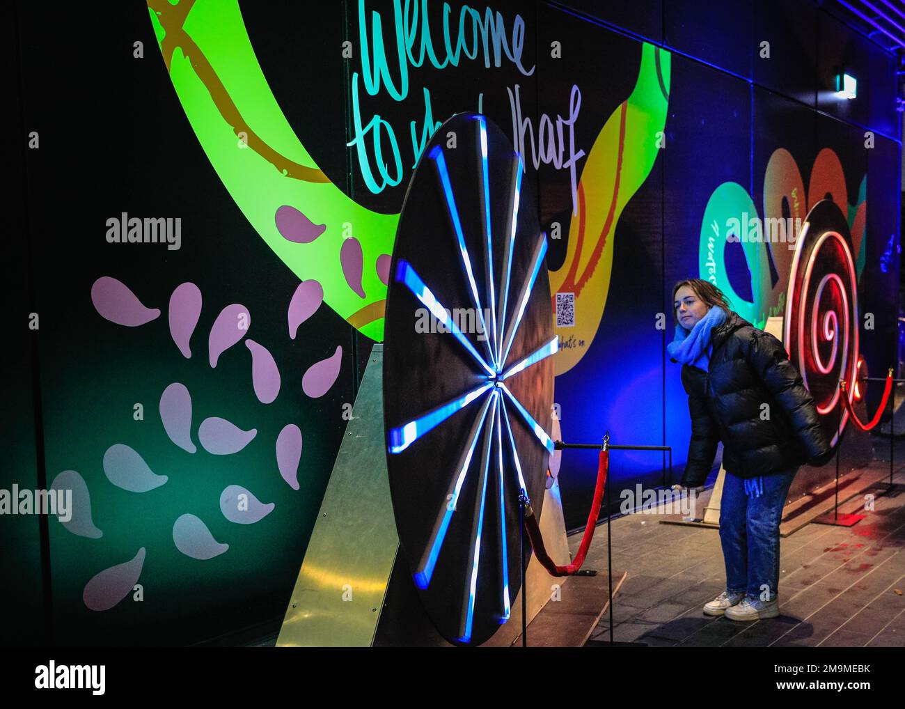 Londra, Regno Unito. 18th Jan, 2023. Una donna gira la ruota di Intonaluci (le lumache di luce) di Calidos, che si trova in Crossrail Place Roof Garden. L'annuale Winter Lights Festival viene lanciato oggi con 22 installazioni di luci e coinvolgenti mostre d'arte sparse intorno a Canary Wharf a Londra. Il festival pubblico è aperto fino al 28th gennaio ed è gratuito. Credit: Imageplotter/Alamy Live News Foto Stock