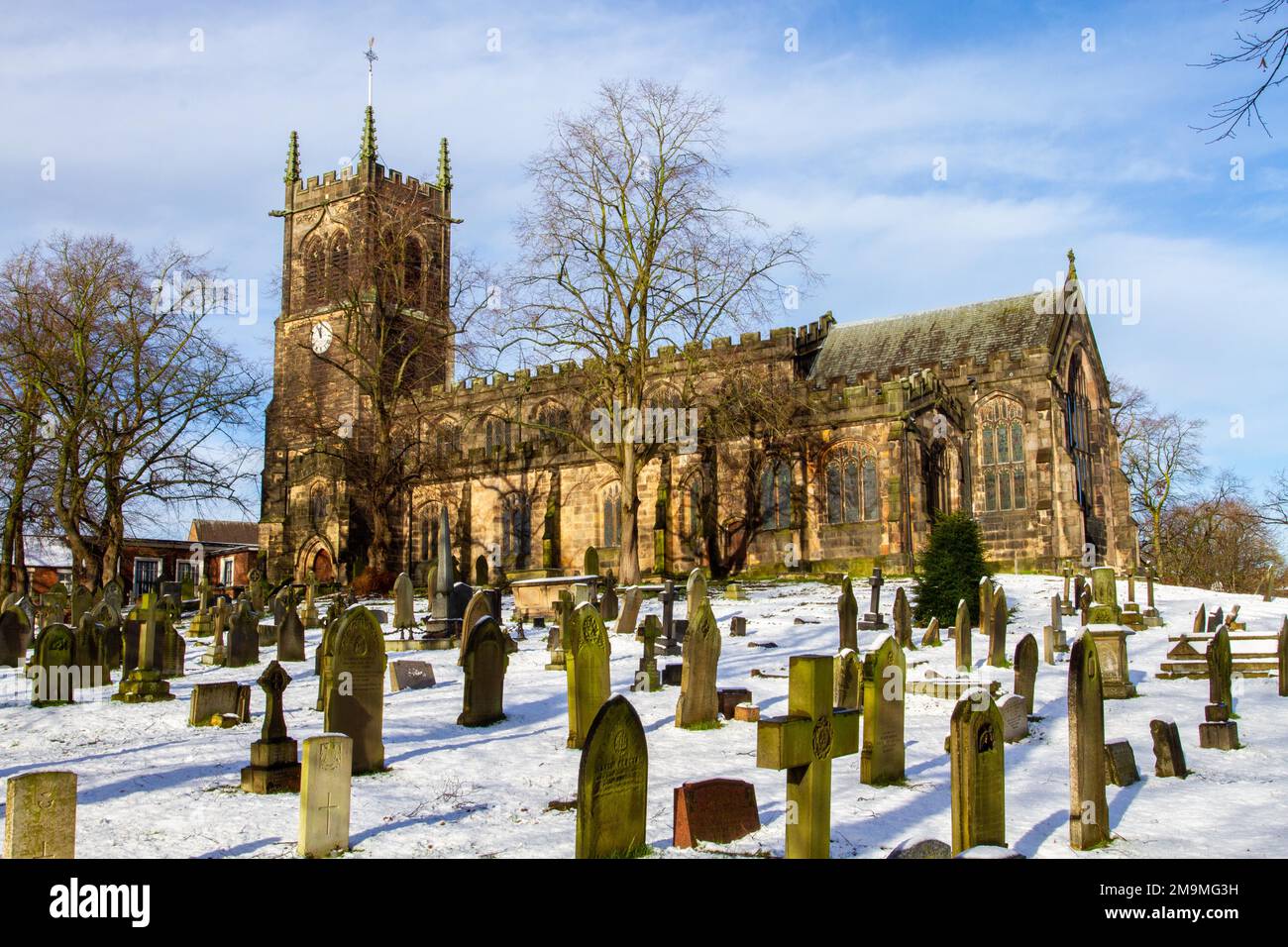Il cimitero innevato e le lapidi nella parrocchia di Santa Maria chiesa Sandbach Cheshire Inghilterra in inverno Foto Stock