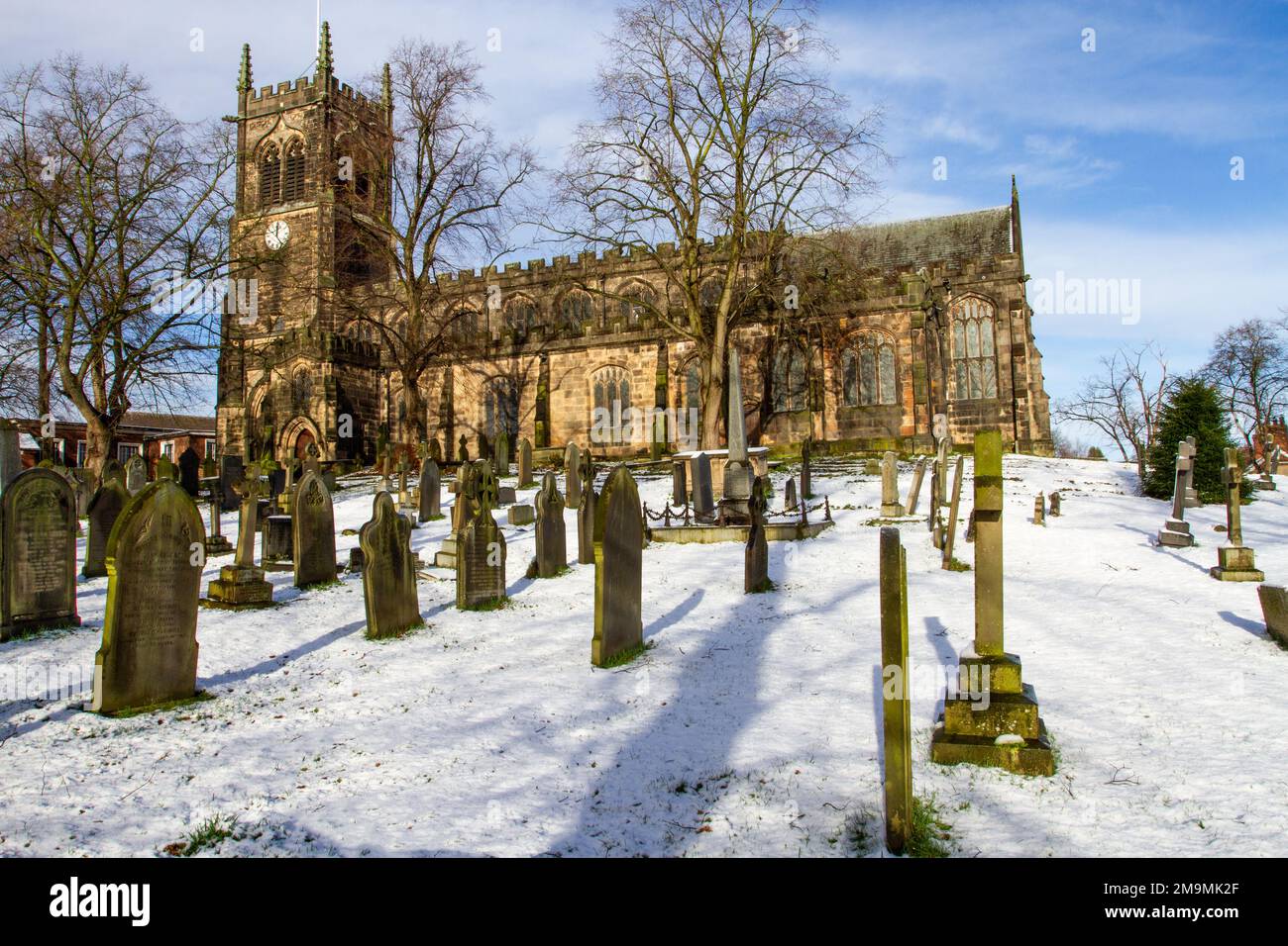 Il cimitero innevato e le lapidi nella parrocchia di Santa Maria chiesa Sandbach Cheshire Inghilterra in inverno Foto Stock