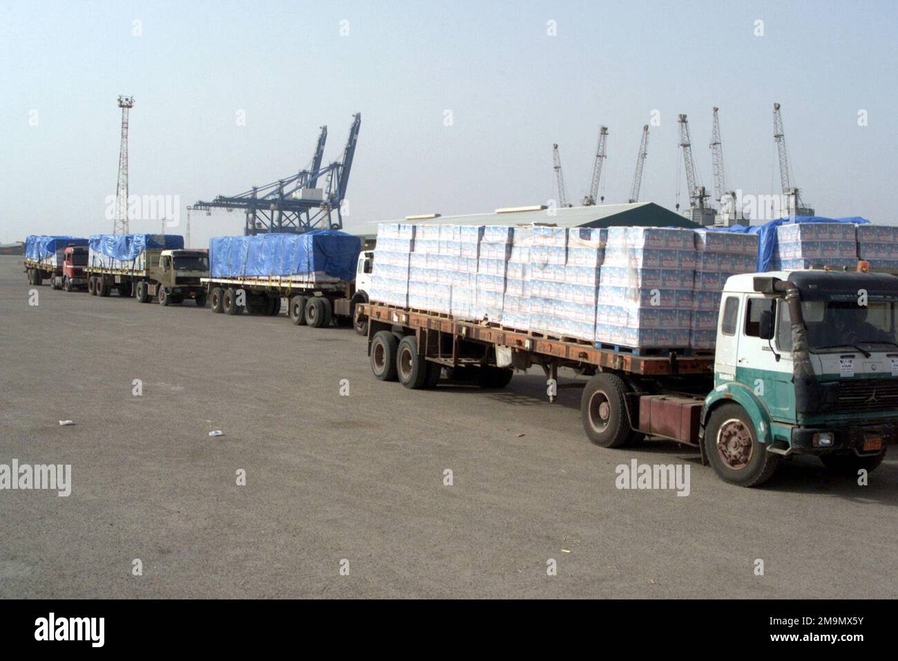 Camion carichi di assistenza umanitaria e di soccorso arrivano in un magazzino nel porto di Umm Qasr, in Iraq, durante l'operazione IRACHENA LIBERTÀ. Soggetto operativo/Serie: BASE PER LA LIBERTÀ IRACHENA: Umm Qasr Paese: Iraq (IRQ) Foto Stock
