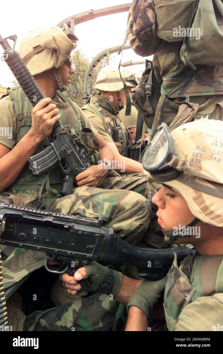 Marines di Echo Company, Battalion Landing Team (BLT), 2nd Battalion, 2nd Marines, 24th Marine Expeditionary Unit (Special Operations Capable) (MEU SOC) armato di fucili M16A2 da 5,56 mm e una mitragliatrice Saco da 7,72 mm M60 per scopi gererali, Sali a bordo di un veicolo di ricambio tattico medio (MTVE) lungo il tragitto per assicurare l'edificio della sede centrale del Baa'th Party a Qalat Sukar, Iraq. Soggetto operativo/Serie: BASE PER LA LIBERTÀ IRACHENA: Qalat Sukar Stato: Dhi Qar Paese: Iraq (IRQ) Foto Stock