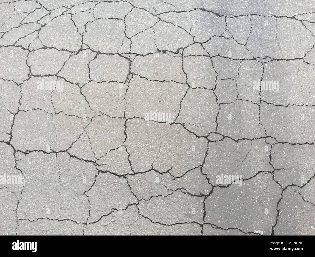 Un colpo verticale dall'alto di asfalto incrinato - perfetto per lo sfondo Foto Stock