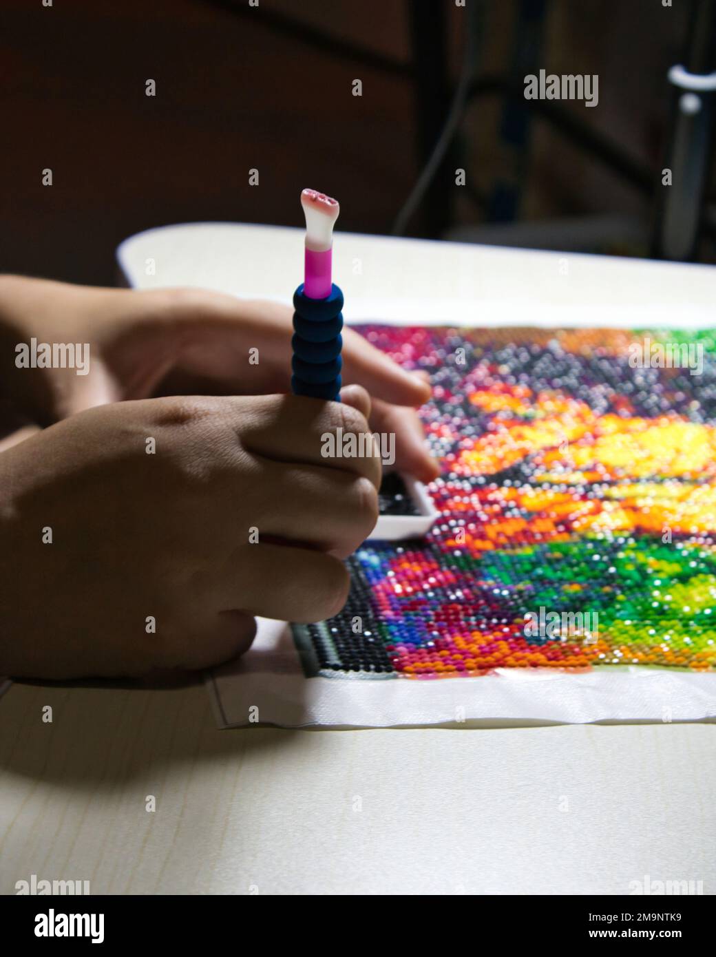 Un primo piano di una persona che fa una pittura di diamante Foto Stock