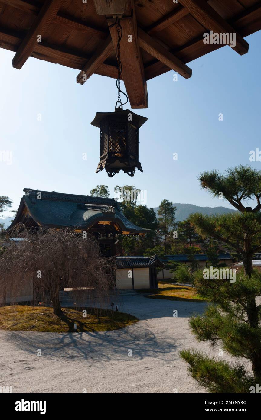 Una lanterna è appesa alle gronde sopra il giardino al Tempio Daikaku-ji, Kyoto, Giappone. Foto Stock