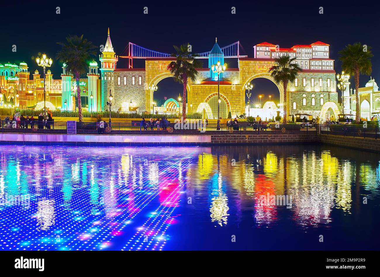 DUBAI, Emirati Arabi Uniti - 6 MARZO 2020: Lo spettacolo di luci sullo schermo a LED subacqueo nello stagno del Global Village Dubai, con padiglioni di diversi paesi sul retro Foto Stock