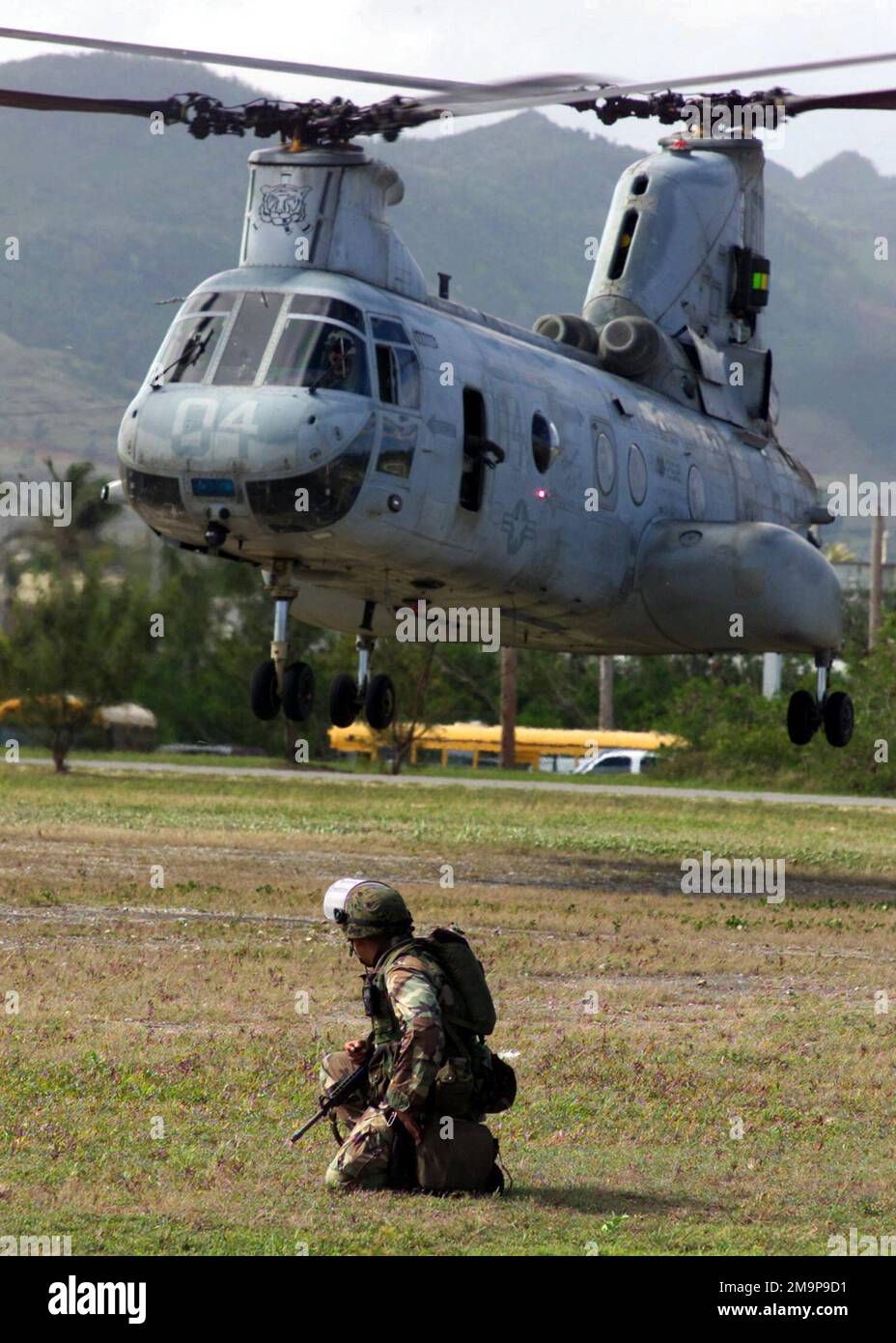Caporale (CPL) Douglas Aleman, Gulf Company, 2nd battaglione, 11th Regimento Marino guarda come un cavaliere di mare CH-46 da Marine Medium Helicopter Squadron (HMM 262) atterra per raccogliere gli evacuati da un'operazione di evacuazione non combattente simulata (NEO), a sostegno dell'esercizio TANDEM SPINTA 2003. Oggetto/Serie: TANDEM THRUST 2003 Stato: Guam Paese: Isole Marianne Settentrionali (MNP) Foto Stock