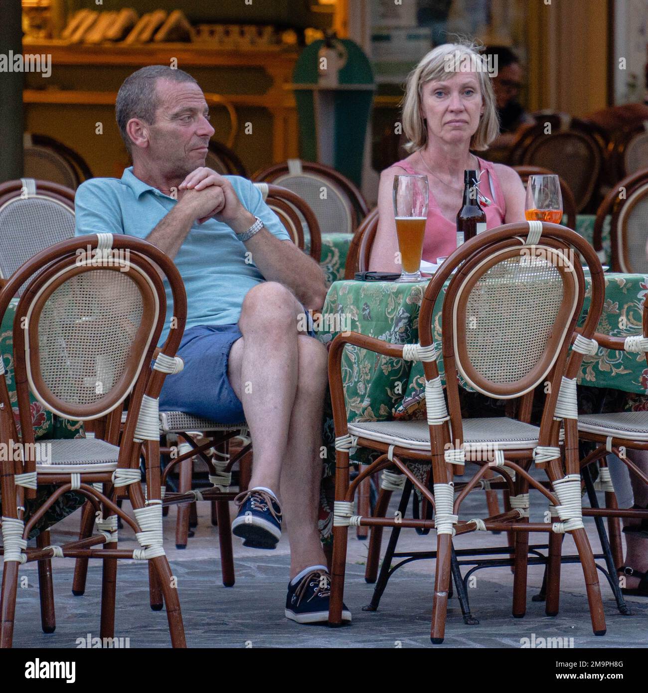 Un uomo e una donna, una coppia sposata, sono seduti in un bar di strada che sperimenta problemi di famiglia. Foto Stock
