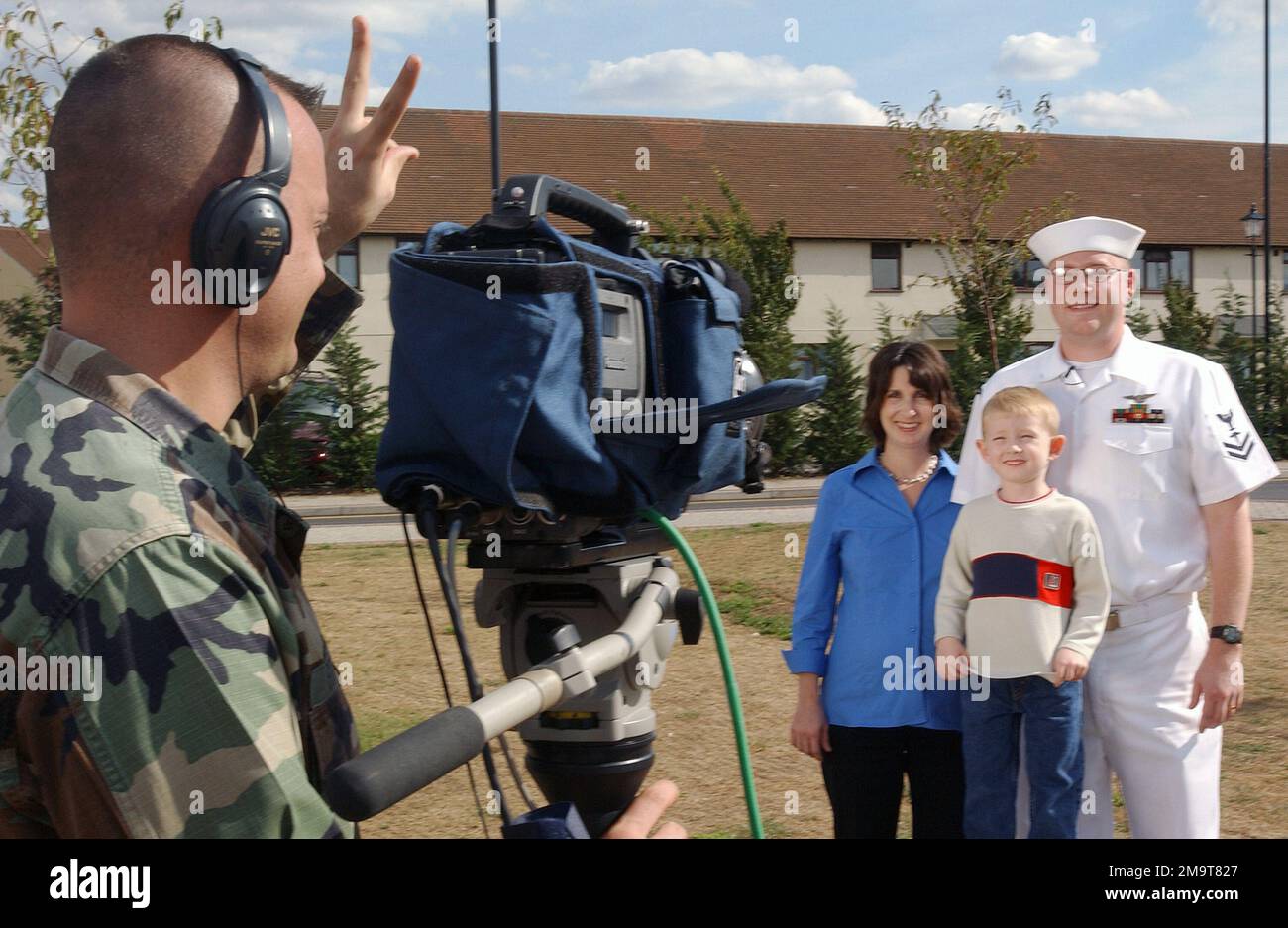 US Navy (USN) Hospital Corps Man Second Class (HM2) Martin Brown, la moglie Lynn, e il figlio di 4 anni Nicholas, inviano a casa i loro saluti per la famiglia, gli amici e la città natale, mentre il team di saluti Hometown Holiday visita Royal Air Force (RAF) Mildenhall, Inghilterra (ENG). Base: RAF Mildenhall Stato: Suffolk Paese: Inghilterra / Gran Bretagna (ENG) Foto Stock