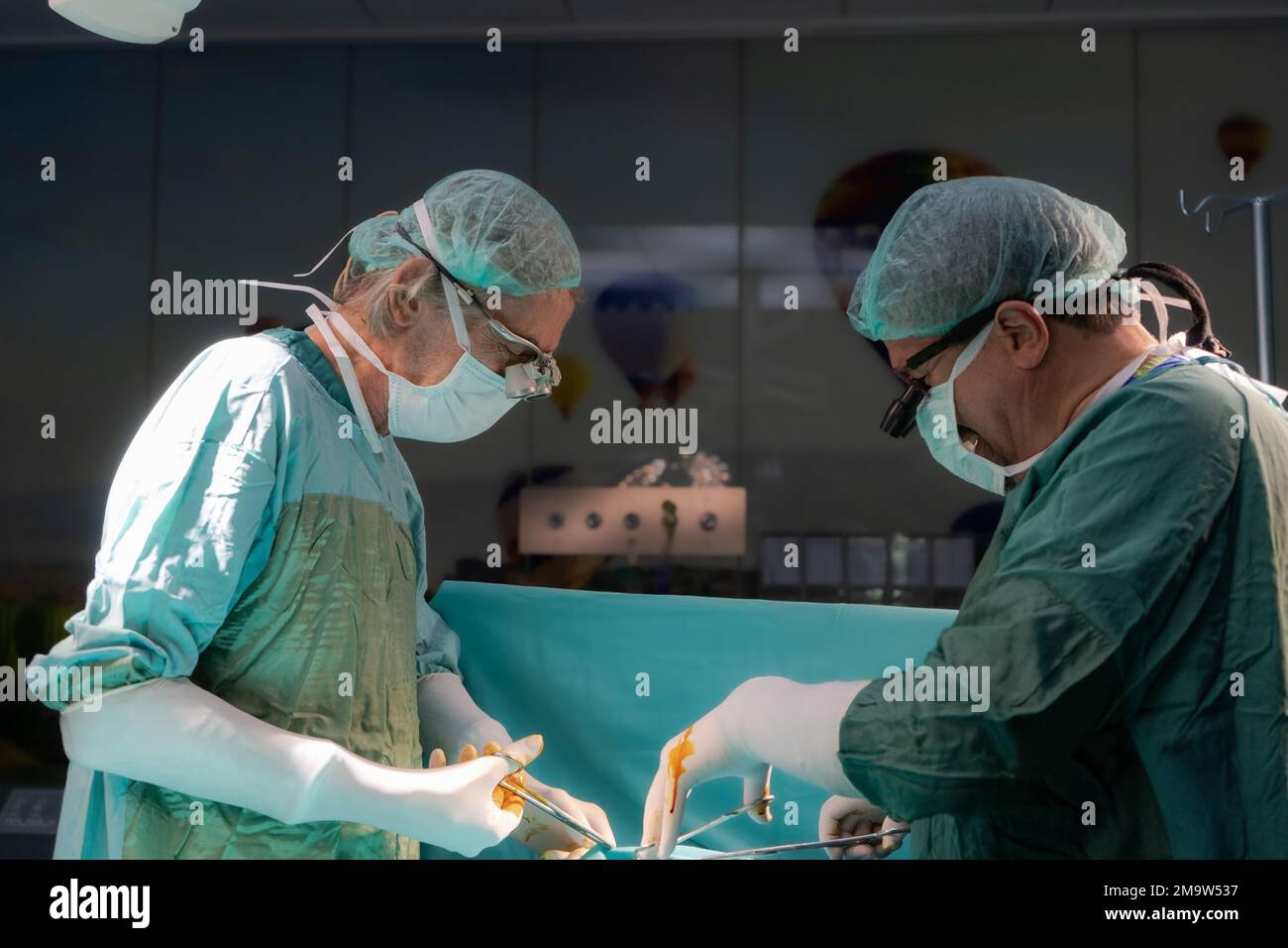 Medico di chirurgia a cuore aperto eseguire chirurgia a cuore aperto. Medici in uniformi verdi sono in sala operatoria Foto Stock