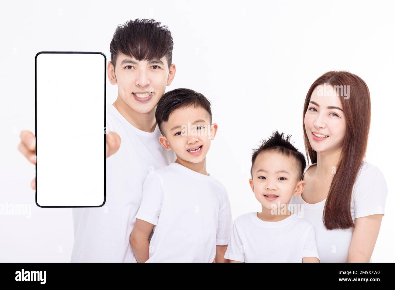 Famiglia felice che mostra lo schermo vuoto del telefono cellulare Foto Stock