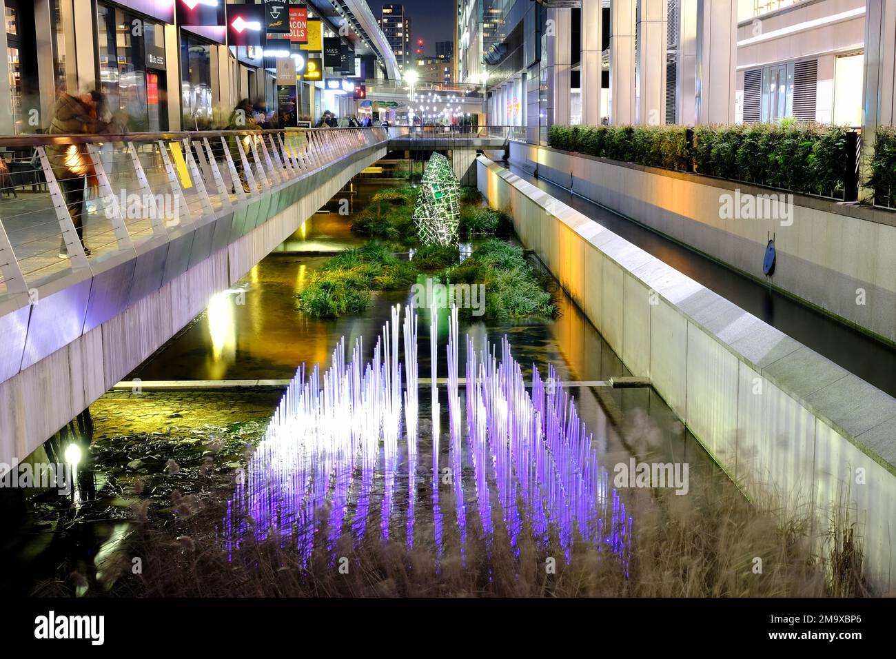 Londra, Regno Unito. 18th gennaio 2023. Elantica The Boulder (background) di Tom & Lien Dekywere e abbiamo potuto incontrare Martin Richman (in primo piano). Il Winter Lights Festival torna a Canary Wharf con 22 installazioni al neon e LED al coperto e all'aperto, per consentire ai visitatori di godersi un percorso coinvolgente. Credit: Undicesima ora di Fotografia/Alamy Live News Foto Stock