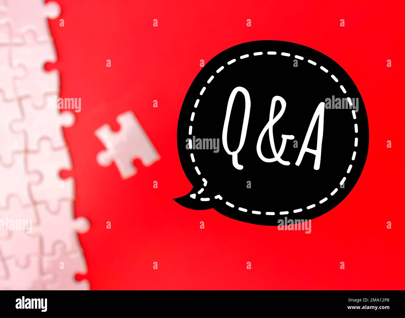 Blur pezzi di puzzle bianchi infiniti su sfondo rosso con la parola Q E A. Foto Stock