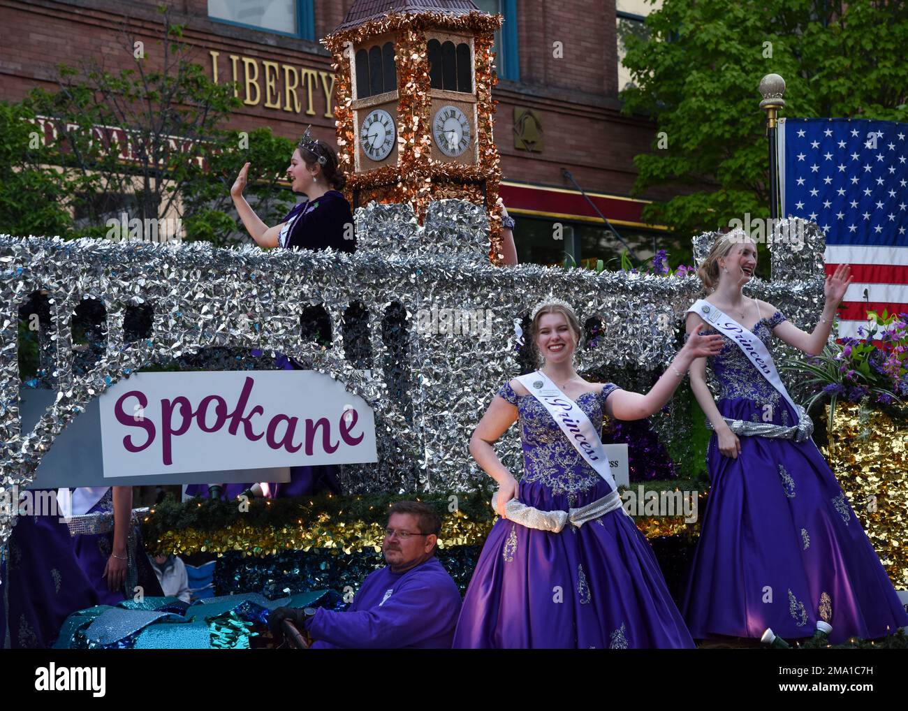 Le principesse di Spokane Lilac ondeggiano dal loro galleggiante, durante la parata delle forze armate del Festival di Spokane Lilac che inizia a Spokane, Washington, il 21 maggio 2022. Il tema della sfilata di quest’anno era “la nostra città”, con l’obiettivo di riunire tutta la comunità dopo la sfilata passata e le cancellazioni di eventi dovute al COVID-19. Foto Stock