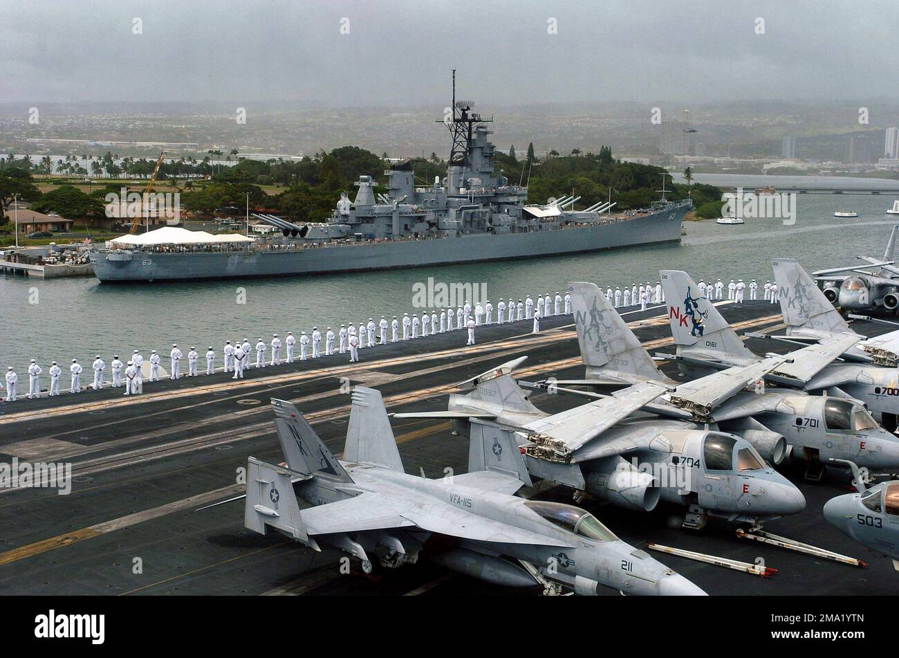 040629-N-6213R-137. [Complete] Scene Caption: US Navy (USN) marinai 'an the rails' a bordo della USN Nimitz Class Aircraft Carrier USS JOHN C. STENNIS (CVN 74) come lei passa il MISSOURI Battleship (BB 63) Memorial al suo arrivo a Pearl Harbor, Hawaii. In primo piano c'è un F/A-18 Hornet, Strike Fighter Squadron 115 (VFA-115), Eagles, Naval Air Station (NAS) Lemoore, California (CA), e S-3B Vikings, Sea Control Squadron 35 (VS-35), Blue Wolves, Naval Air Station North Island (NASNI), CA. La STENNIS e la Carrier Air Wing 14 (CVW-14) partecipano alla Rim of the Pacific (RIMPAC) 2004. RIMPA Foto Stock