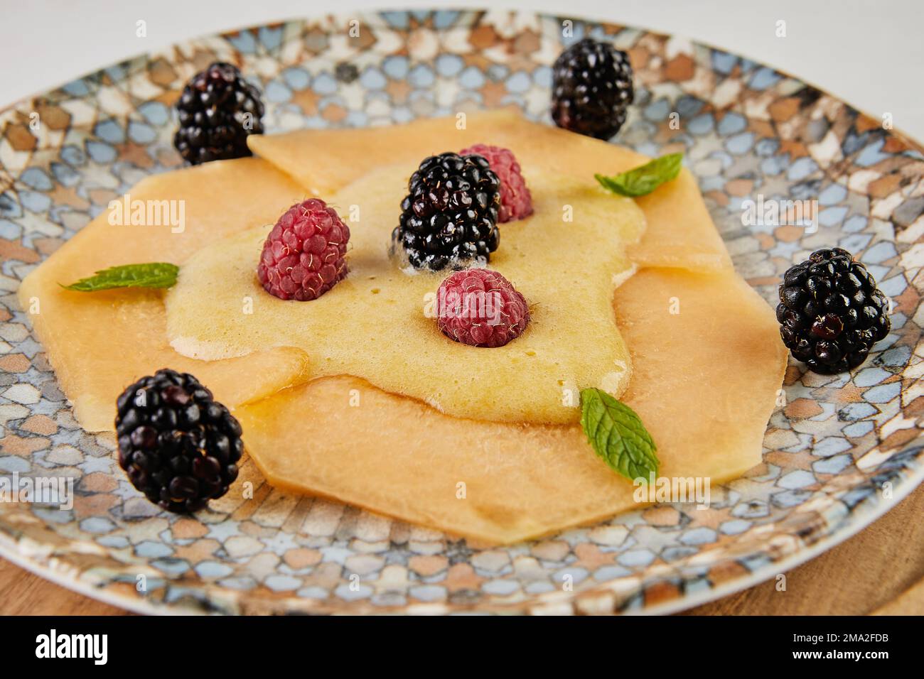 Carpaccio di melone con lamponi freschi e mirtilli a bordo. Foto Stock
