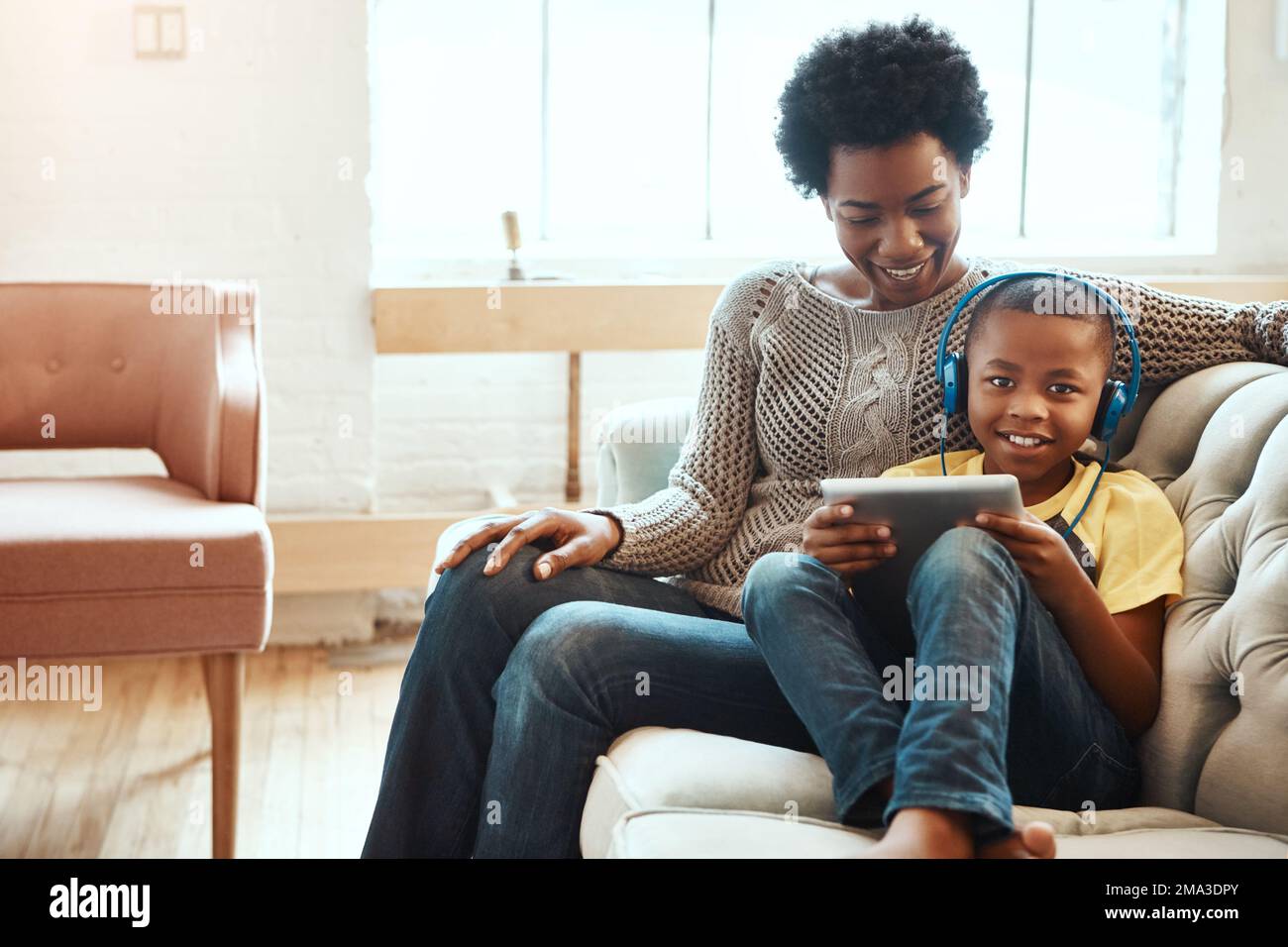 Madre, bambino e tablet per guardare intrattenimento, film o elearning sul divano del soggiorno a casa. Buona mamma nera che si rilassa con il figlio Foto Stock