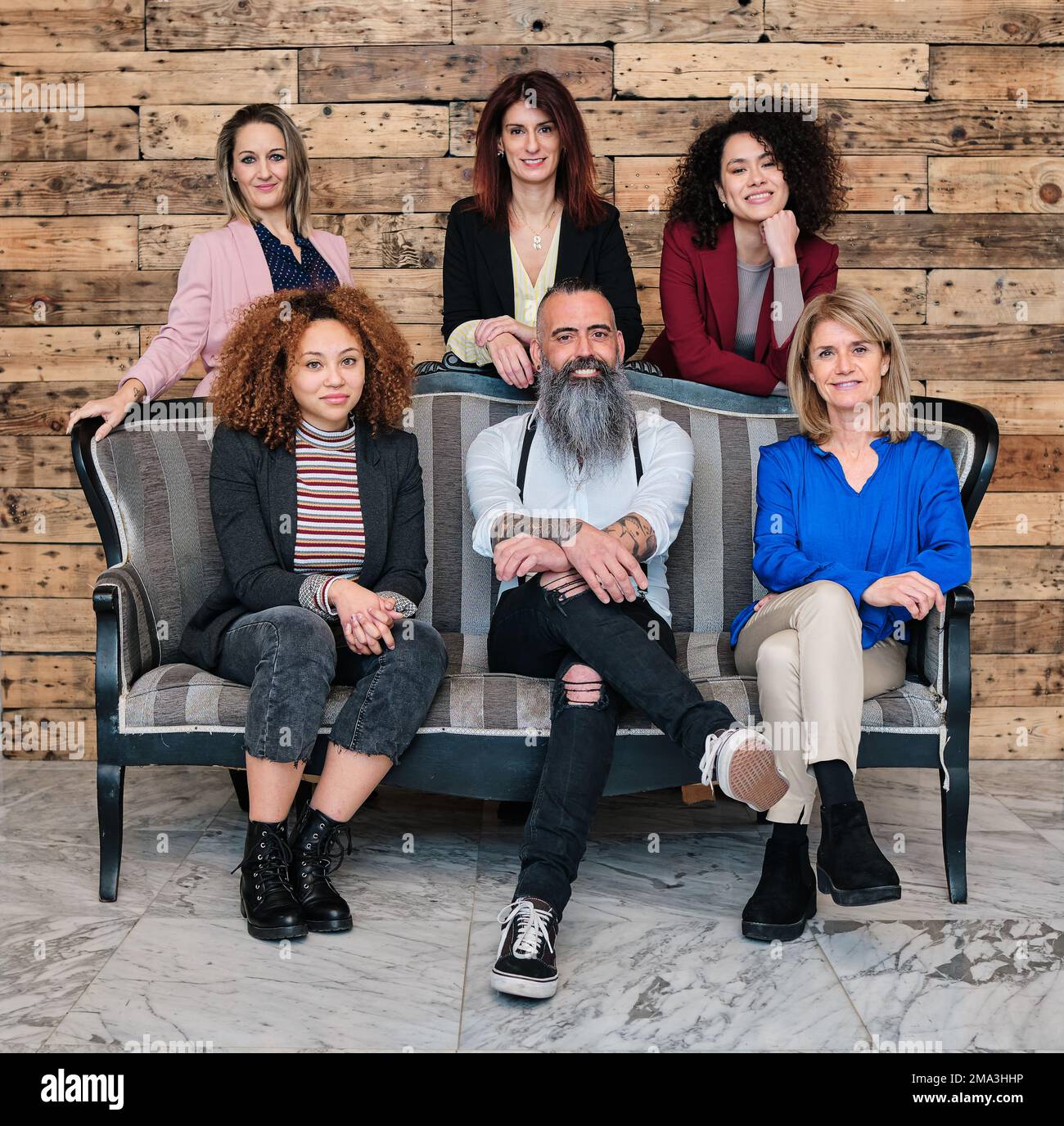 Un gruppo eterogeneo di uomini d'affari che guardano la fotocamera mentre si posano insieme nel proprio ufficio. Foto Stock