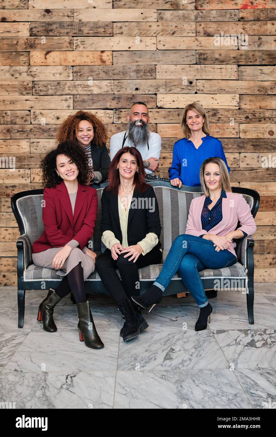 Un gruppo eterogeneo di uomini d'affari che guardano la fotocamera mentre si posano insieme nel proprio ufficio. Foto Stock