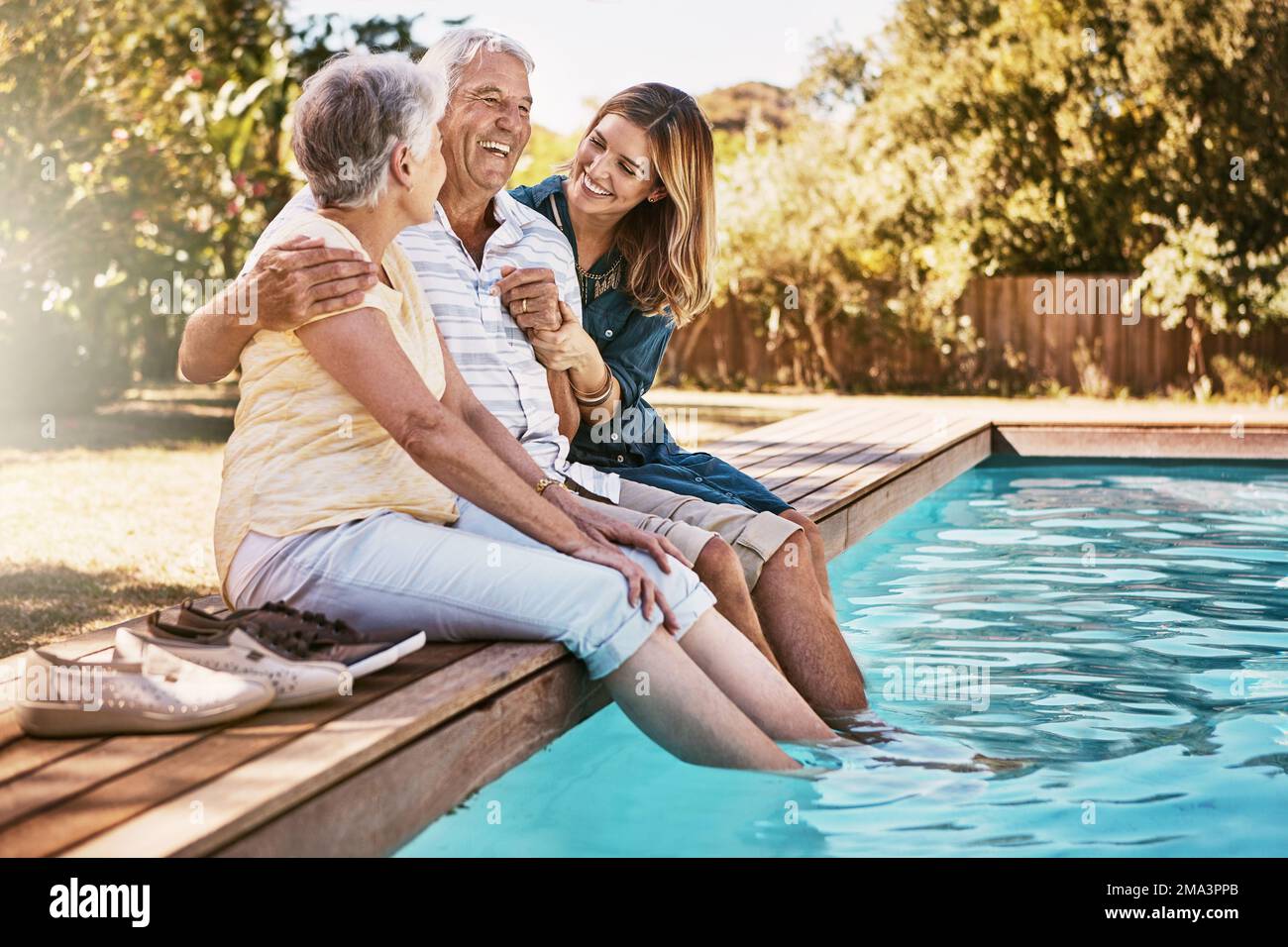 Relax, coppia e donna senior con piedi in piscina godendo vacanze estive, vacanze e fine settimana. Famiglia, amore e figlia con anziani Foto Stock