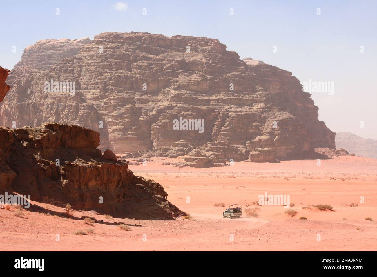Safari in auto nel deserto di Wadi Rum, Giordania. I turisti in auto cavalcano in fuoristrada sulla sabbia tra le splendide rocce. Paesaggio desertico con sabbia rossa e roccia Foto Stock