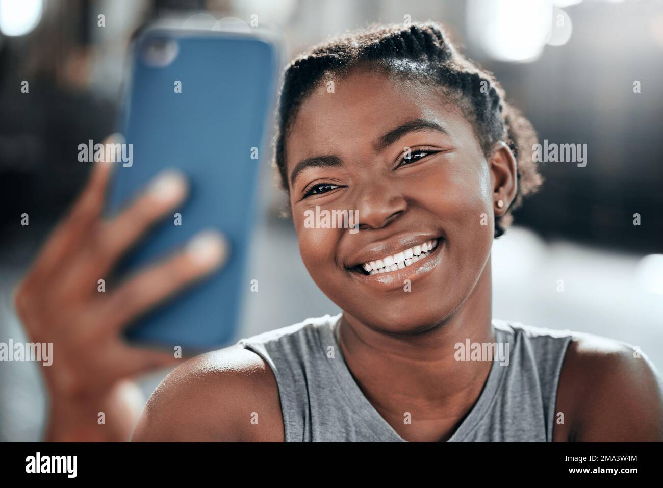 Nessun uomo potrebbe soffiare fuori questo fuze. una giovane bella donna che usa il cellulare per fare un selfie dopo il suo allenamento in palestra. Foto Stock