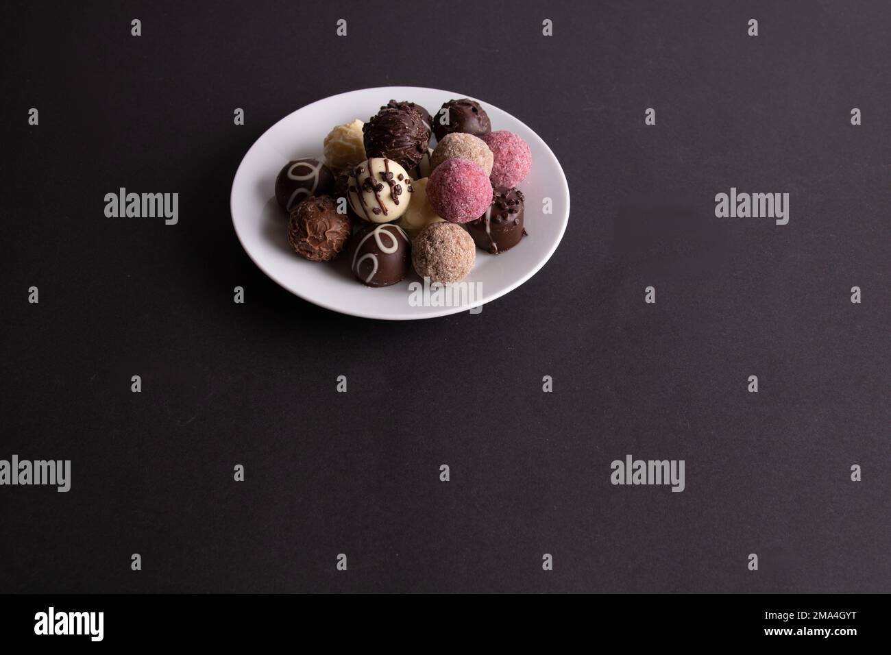 fotografa diversi giri di caramelle giacenti su un piatto Foto Stock