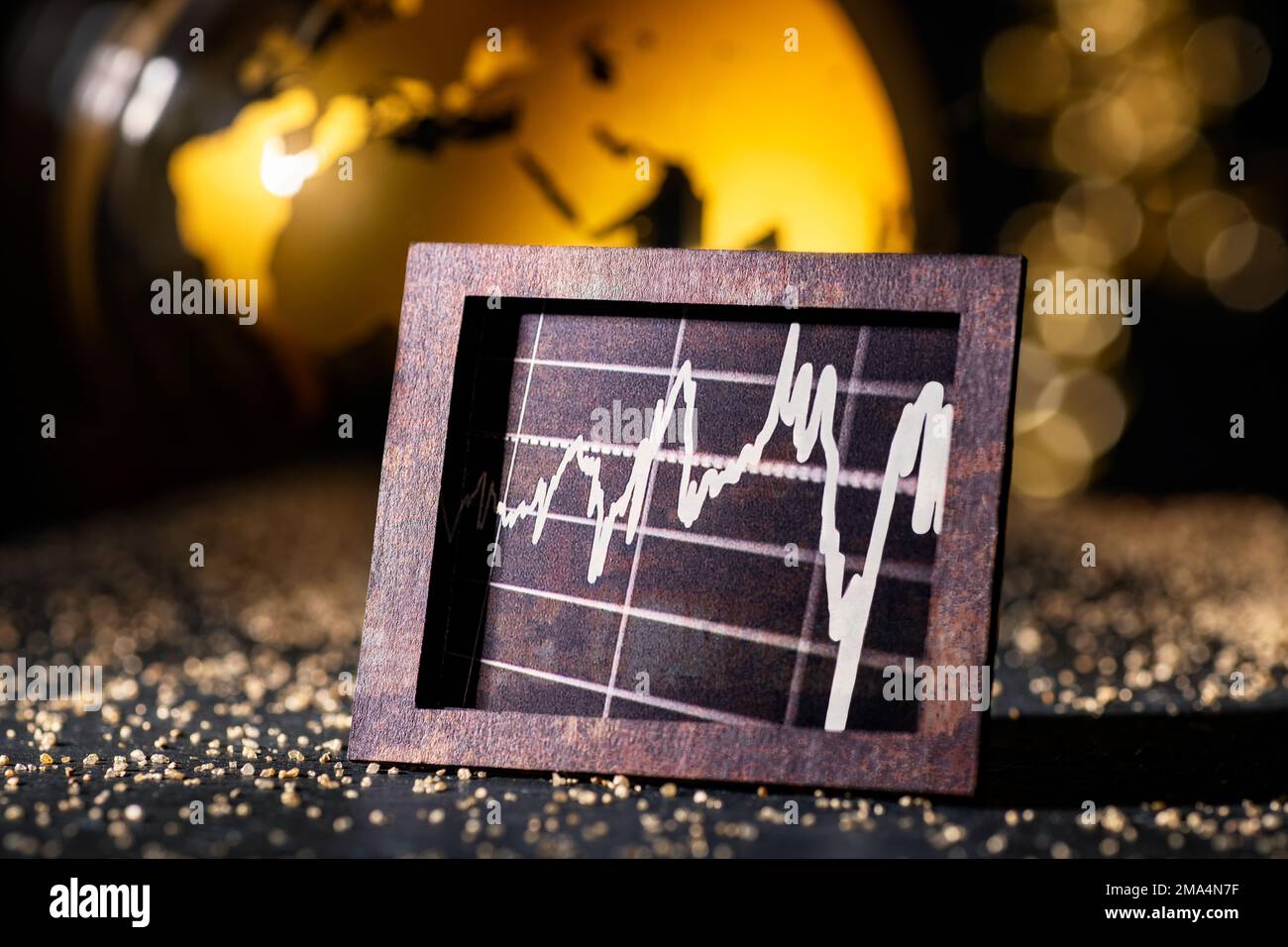 Economia e finanza internazionali. Grafica in vecchia cornice metallica di fronte al globo dorato. Foto Stock