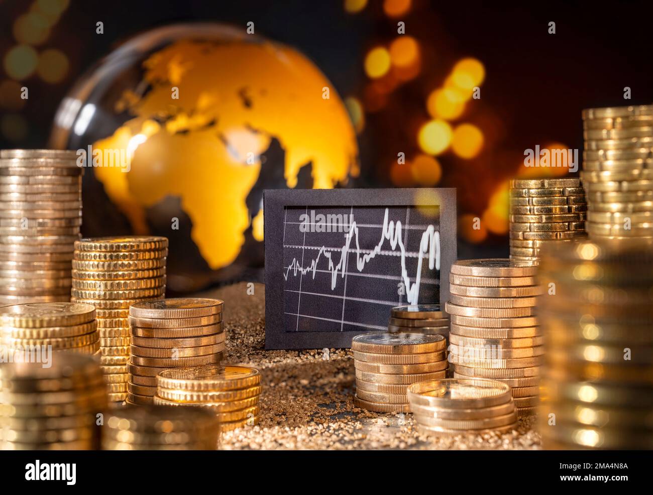 Mercato azionario ed economia internazionale. Grafica e stack con denaro di fronte al globo dorato. Foto Stock