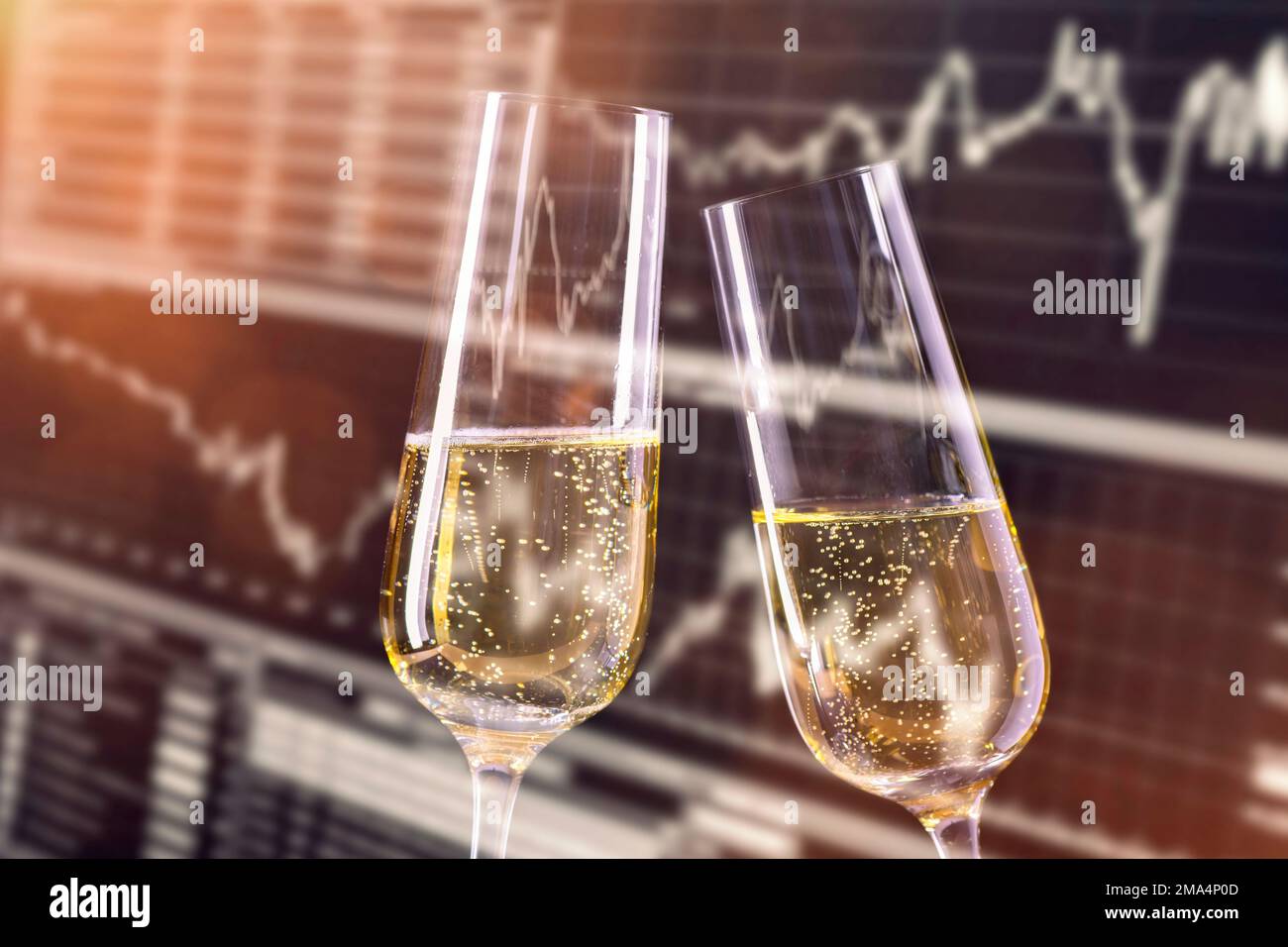 Motivo per festeggiare alla borsa. Bicchieri da champagne e monitor con i prezzi del mercato azionario in background. Foto Stock