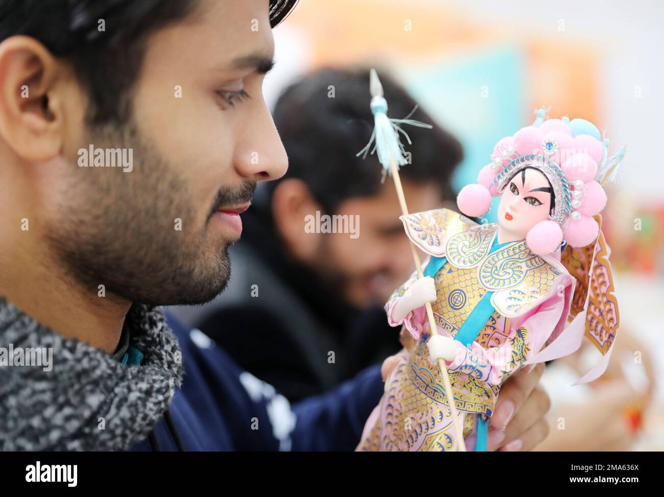 QINGDAO, CINA - 19 GENNAIO 2023 - uno studente d'oltremare pakistano guarda una scultura di seta a Qingdao, provincia dello Shandong, 19 gennaio 20 Foto Stock