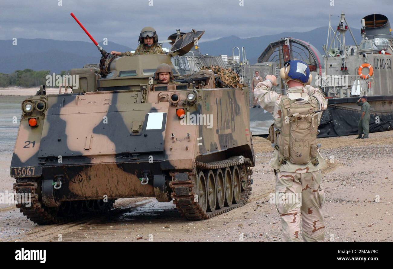 050619-N-3455P-007. [Completa] Scene Caption: Un Beachmaster US Navy (USN), Assault Craft Unit 5 (ACU-5), Marine Corps base (MCB) Camp Pendleton, California (CA), imbarcato a bordo della nave da assalto anfibio USN Wasp Class USS BOXER (LHD 4), dirige un Armored Personnel Carrier australiano M113 (APC), un atterraggio USN Cuscino d'aria (LCAC) a Sabina Point durante l'esercizio TALISMANO SABER 2005. TALISMAN SABER è un esercizio sponsorizzato congiuntamente dal comando del Pacifico degli Stati Uniti (USPACOM) e dal comando delle operazioni congiunte della forza di difesa australiana, e progettato per formare il personale del comandante della flotta degli Stati Uniti 7th e Aust Foto Stock